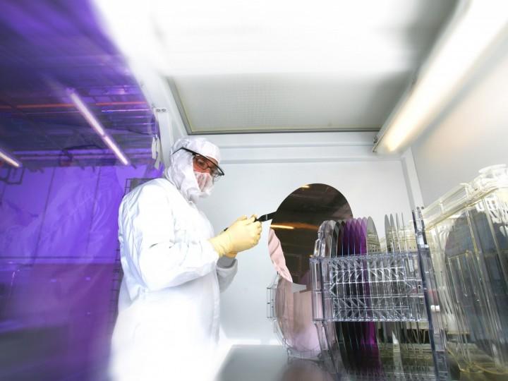 A cleanroom worker stands in lab space