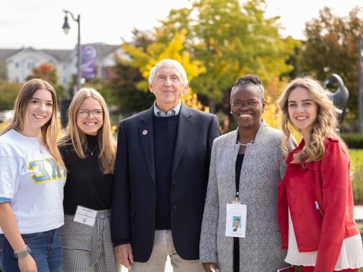 President Tofade stands with a group of students and alumni member at alumni weekend